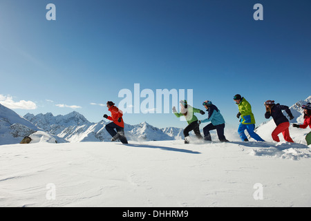 Friends running in snow, Kuhtai, Austria Stock Photo