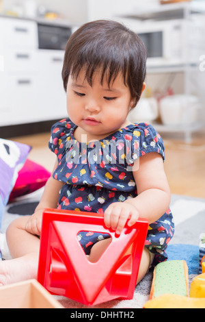 Baby girl playing on floor Stock Photo