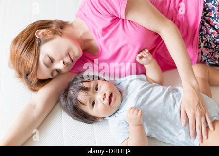 Mother and baby lying on floor Stock Photo