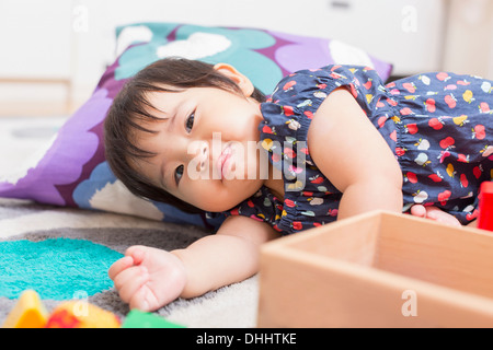 Baby girl playing on floor Stock Photo