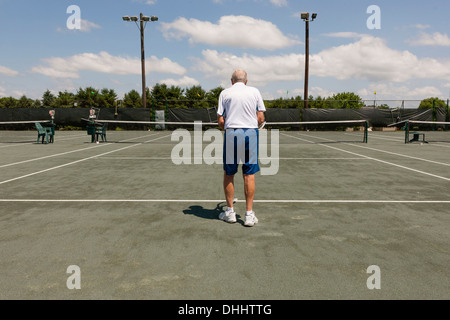Rear view of senior man on tennis court Stock Photo