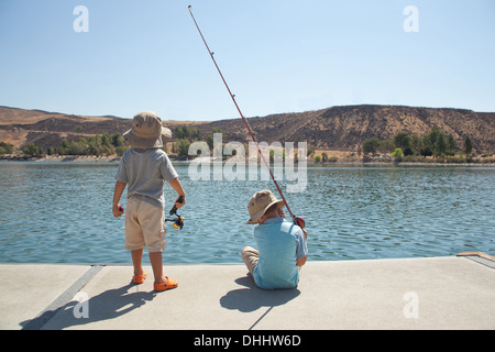 Boys fishing by lake Stock Photo