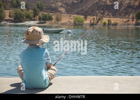 Boy fishing by lake Stock Photo