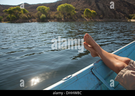 Boy relaxing with feet up on boat Stock Photo