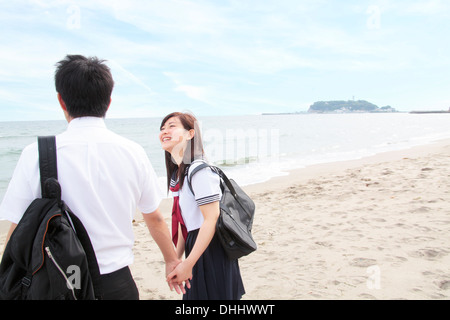 Young couple holding hands on beach, rear view Stock Photo