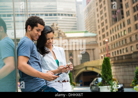 Couple reading text message on mobile phone Stock Photo