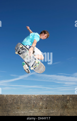 Teenage boy mid air on skateboard Stock Photo