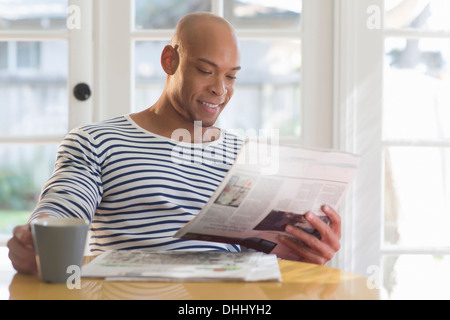 Mid adult man reading newspaper Stock Photo