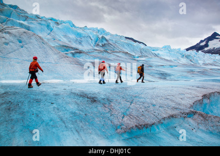 Four people walking on Mendenhall Glacier, Alaska, USA Stock Photo