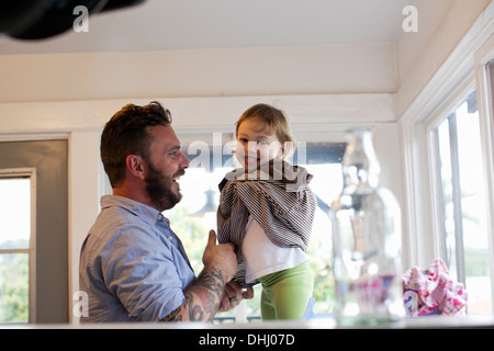 Father getting daughter dressed Stock Photo