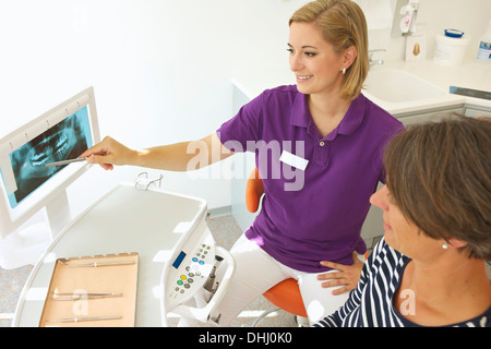Dentist showing patient xray of dental implants Stock Photo