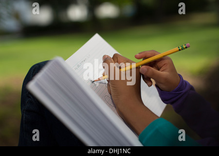 Close up of sisters in park writing in notebook Stock Photo