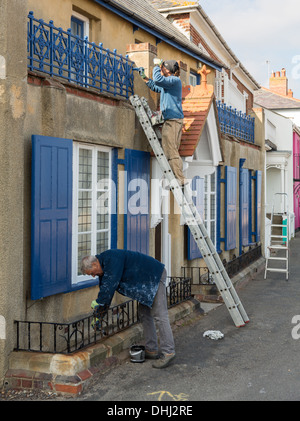 Two decorators painting the outside of a house, UK. Stock Photo