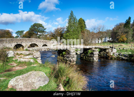 An ancient clapper bridge and arched bridge crossing the East Dart river at Post Bridge on Dartmoor Stock Photo