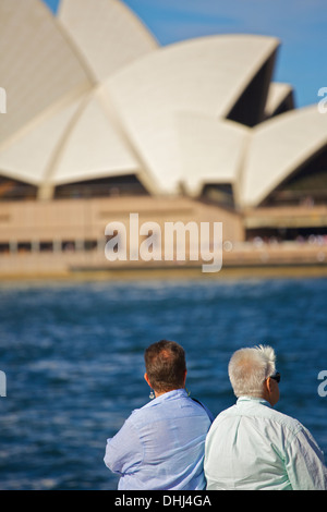 Two Ladies stand by the water looking out towards the Sydney Opera House. Stock Photo