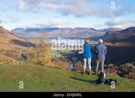 Couple looking out over Derwentwater from Castle Crag summit, Borrowdale, Cumbria, England, UK Stock Photo