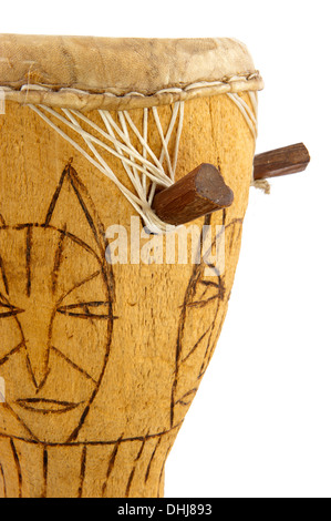 African drum carved from tree trunk decorated with cat like face in closeup Stock Photo