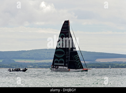 Fastnet yacht race 2013. Racing yacht sailing down the Solent after the start from Cowes. Competing Transat Jacques Vabre 2013. Stock Photo