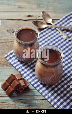 Chocolate dessert panna cotta in glass jars on wooden background Stock Photo