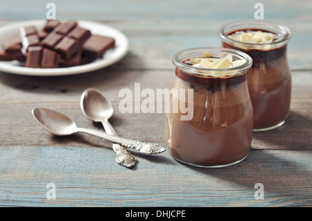 Chocolate dessert panna cotta with almond in glass jars on wooden background Stock Photo