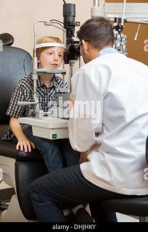 Optician Examining Boy's Eyes With Slit Lamp