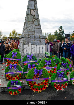 BURNABY, BRITISH COLUMBIA, CANADA – Monday November 11, 2013:  People observing the cenotaph decorated with wreaths and poppies following the Remembrance Day service in Confederation Park, Burnaby, BC. Canada.  Hundreds of people from the community gathered for the annual ceremony, to show respect and thanks to war veterans past and present. Stock Photo