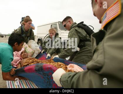 Banda Aceh, ACEH, INDONESIA, . 3rd Jan, 2005. LIEUTENANT LISA PETERSON, 32, FROM LAMORE, CALIFORNIA (CENTRE) A DOCTOR ON THE US CARRIER ABRAHAM LINCOLN, TREATS A MEDIVAC PATIENT BROUGHT IN BY US NAVY HELICOPTER FROM THE WEST COAST OF ACEH PROVINCE WHICH WAS DEVAACEHD BY THE 26 DECEMBER, 2004 TSUNAMI, BANDA ACEH AIRPORT, 03 JANUARY, 2005. SHE IS ASSISTED BY ABRAHAM LINCOLN CREWMATES REBECCA MCCLUNG (LEFT), 38, FROM CLEARWWATER KANSAS, AND JIM JONES, 29 FROM GILBOA NEW YORK. © Stephen Shaver/ZUMAPRESS.com/Alamy Live News Stock Photo