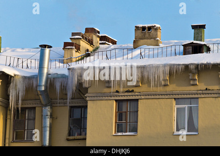 Huge icicles hang down from roof Stock Photo