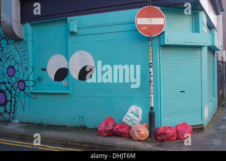 Rubbish bags waiting to be collected at the corner of Whittle and Tib Streets in Manchesters Northern Quarter with eyes watching Stock Photo