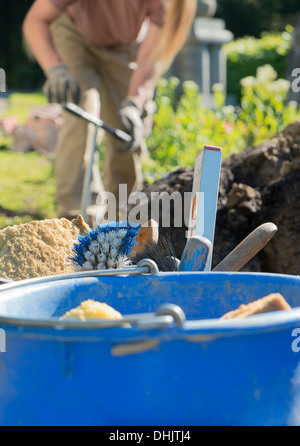 Stonemason working on a grave, tools for bricklaying and concreting Stock Photo