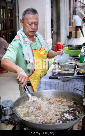 Street vendor on a South East Asian street stall, selling boiled tripe (intestines) Stock Photo