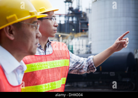 Two engineers in protective workwear pointing outside of a factory Stock Photo