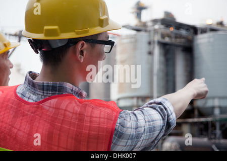 Two engineers in protective workwear pointing outside of a factory Stock Photo