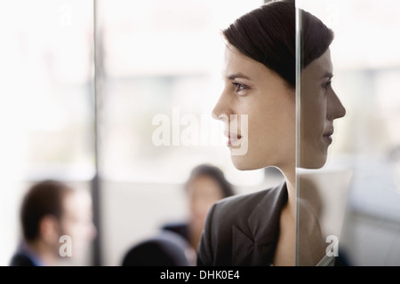 Side profile on a businesswoman with coworkers in the background Stock Photo