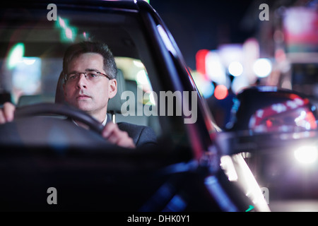 Businessman driving at night in the city Stock Photo