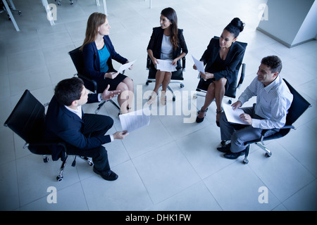 Business people sitting in a circle having a business meeting Stock Photo