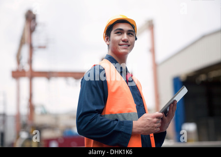 Proud young worker in protective work wear in a shipping yard Stock Photo