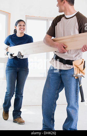 A couple holding a plank of wood Stock Photo