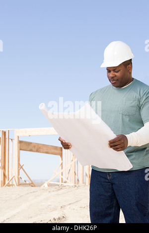 A builder holding a blueprint Stock Photo