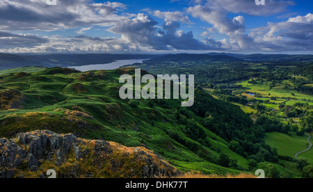 from Loughrigg towards Windermere in the distance, in the morning with shadows on the landscape and patchy cloud. Stock Photo
