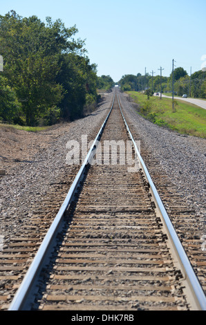 Long straight American train rail track disappears into the distance Stock Photo