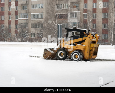 wheel loader machine unloading snow during municipal works crews Stock Photo