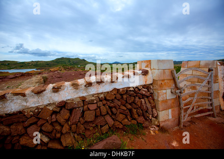 Masonry red stonewall in Menorca with fence door at Balearic islands Stock Photo