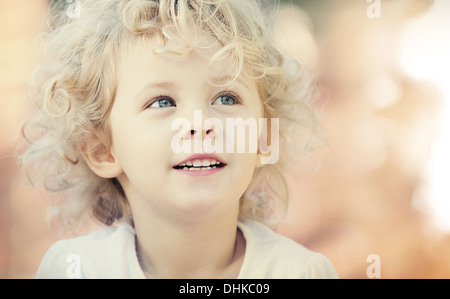 Blonde baby girl smiling outdoor. Closeup vintage portrait Stock Photo