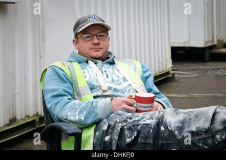 Alexander Renwick, plasterer, having a coffee, sitting outside the site canteen, Fairfield, Govan, Glasgow Stock Photo