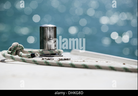 White mooring rope tied around steel anchor on boat or ship Stock Photo