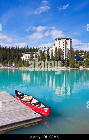 Red canoe for hire on Lake Louise in front of Fairmont Chateau Lake Louise Banff national Park Alberta Canadian Rockies Canada Stock Photo