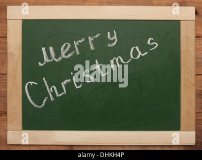 'Merry Christmas' handwritten with white chalk on a blackboard Stock Photo