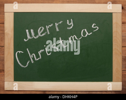 "Merry Christmas" handwritten with white chalk on a blackboard Stock Photo