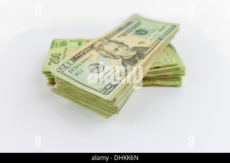 A stack of Us dollars bills and Mexican Pesos bills. Stock Photo